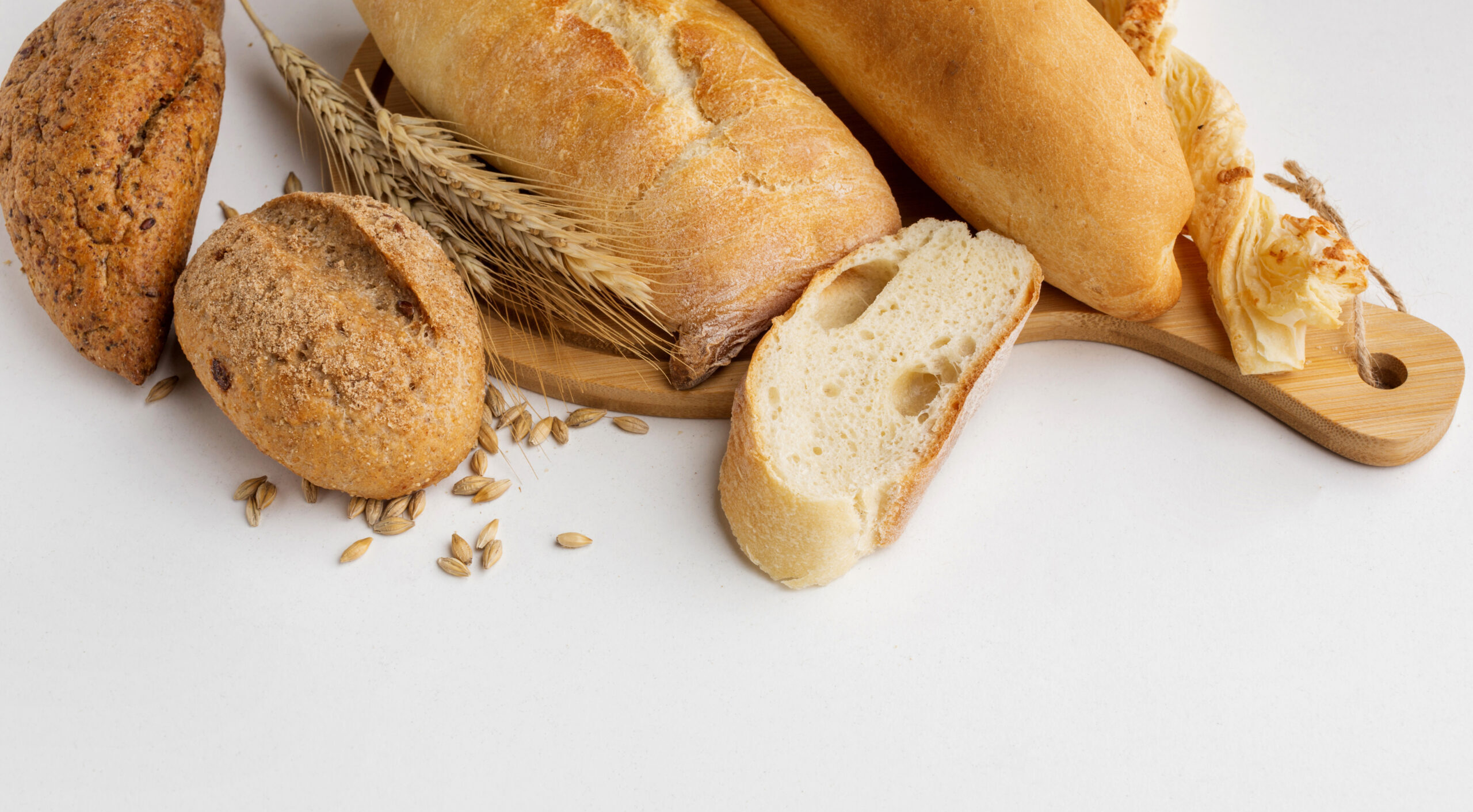 bread and wheat on a white table